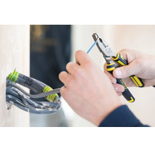 Elektrikár s kombinovanými kliešťami pracujúci na kábli