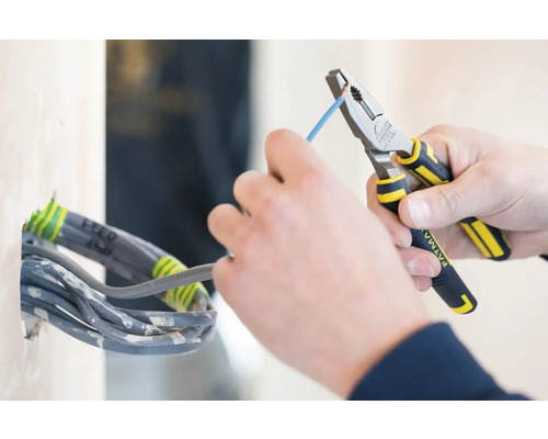 Elektrikár s kombinovanými kliešťami pracujúci na kábli