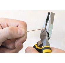 Osoba strihá drôt kombinovanými kliešťami Stanley.