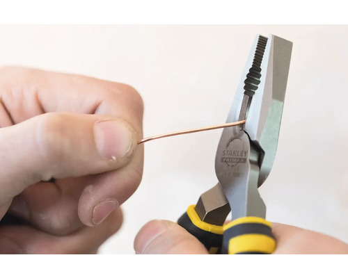 Osoba strihá drôt kombinovanými kliešťami Stanley.