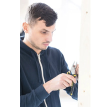 Muž pracuje s odizolovacími kliešťami Stanley na drevenom ráme