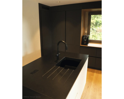 Kuchynská scéna s umývadlom, batériou a kuchynskými spotrebičmi pred oknom