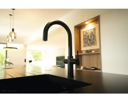 Čierna kuchynská batéria na dreze v modernej kuchyni.