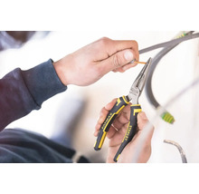 Ruky používajú úzke kliešte Stanley Fatmax na zvliekanie kábla.