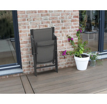 Skladacia záhradná stolička vedľa kvetináča na terase