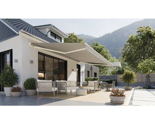 Fasáda domu s vysunutou markízou a záhradným nábytkom na terase.