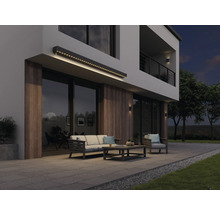 Moderná fasáda domu s osvetlenou markízou, záhradným nábytkom a terasou