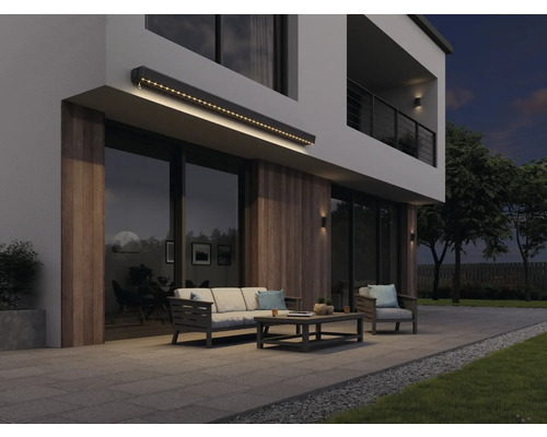 Moderná fasáda domu s osvetlenou markízou, záhradným nábytkom a terasou