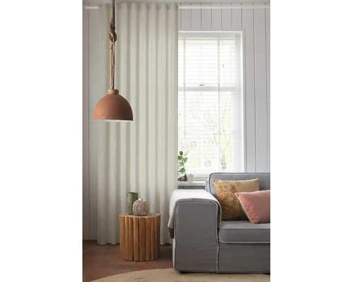 Obývacia izba so sivou pohovkou, dreveným príručným stolíkom a látkovým závesom