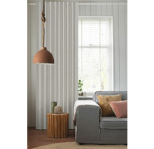 Obývacia izba so závesom, lampou, príručným stolíkom a pohovkou pre útulnú atmosféru.