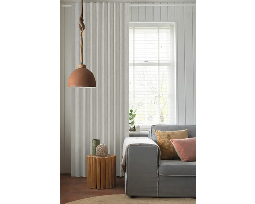 Obývacia izba so závesom, lampou, príručným stolíkom a pohovkou pre útulnú atmosféru.