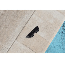 Slnečné okuliare na kamenných dlaždiciach vedľa bazéna