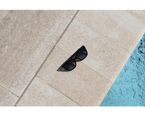 Slnečné okuliare na kamenných dlaždiciach vedľa bazéna