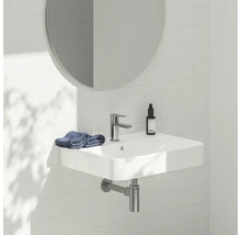 Umývadlo s vodovodnou batériou, zrkadlom a uterákom v kúpeľni