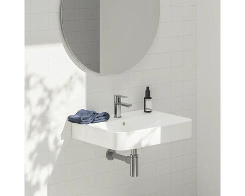 Umývadlo s vodovodnou batériou, zrkadlom a uterákom v kúpeľni