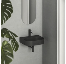 Čierne umývadlo so zrkadlom na stene v kúpeľni