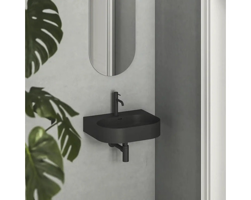 Čierne umývadlo so zrkadlom na stene v kúpeľni