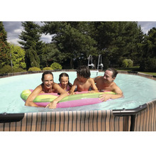 Rodina si užíva plávanie v bazéne s rebríkom v záhrade.