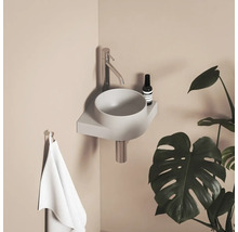 Moderná kúpeľňa s umývadlom na dosku, batériou, uterákom a izbovou rastlinou.