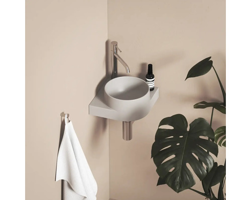 Moderná kúpeľňa s umývadlom na dosku, batériou, uterákom a izbovou rastlinou.