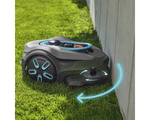 Robotická kosačka na trávu kosí trávu pozdĺž steny