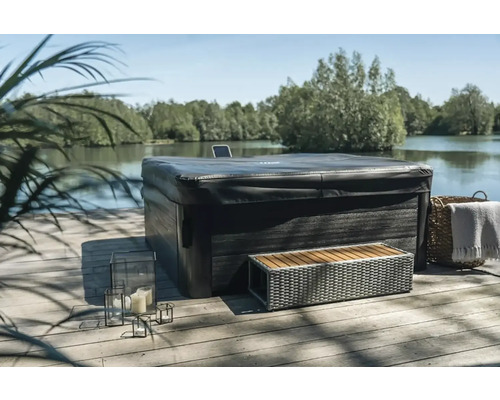 Zakrytá drevená vírivka s lavičkou a dekoráciou vonku