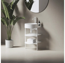 Moderná kúpeľňa s voľne stojacim umývadlom, batériou, úložnými policami a uterákmi