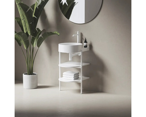 Moderná kúpeľňa s voľne stojacim umývadlom, batériou, úložnými policami a uterákmi