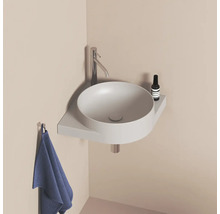 Okrúhle umývadlo s batériou, odkladacou plochou a uterákom v kúpeľni