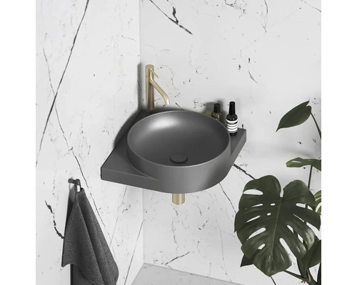 Sivé rohové umývadlo s vodovodnou batériou a uterákom