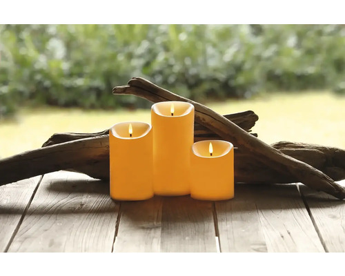 Tri LED sviečky s drevenou dekoráciou na drevenom stole