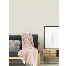 Obývacia izba s pohovkou, vankúšom, dekou, komodou a zarámovaným obrázkom