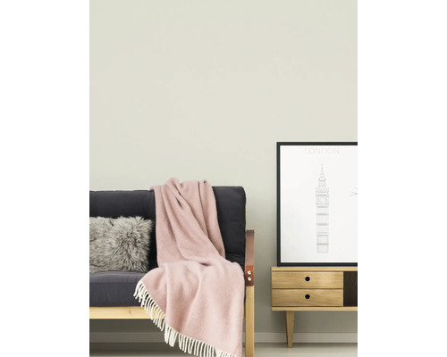 Obývacia izba s pohovkou, vankúšom, dekou, komodou a zarámovaným obrázkom