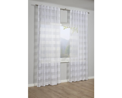 Okno s priehľadnými bielymi závesmi s prúžkovaným vzorom
