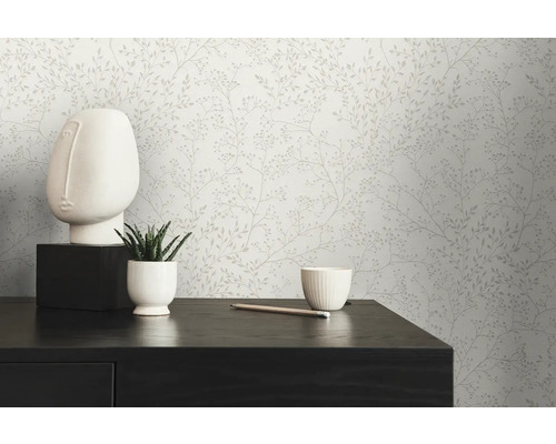 Scéna s kvetinovou tapetou, bielou sochou tváre, sukulentom v kvetináči a ceruzkou na tmavom stole.