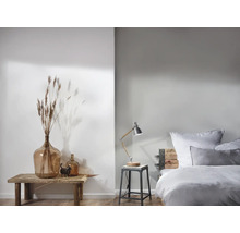 Svetlá spálňa s dekoratívnymi prvkami a nočnou lampou na stoličke