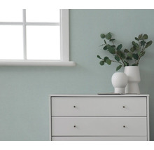 Komoda s dekoráciami pred stenou vedľa okna