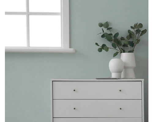 Komoda s dekoráciami pred stenou vedľa okna