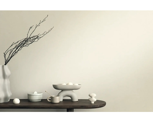 Dekoratívna scéna s vázou, konármi, miskou a keramickými figúrkami na stole