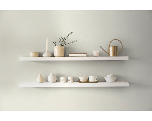 Dve biele police s dekoratívnymi predmetmi na stene