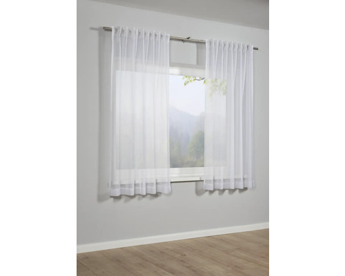 Okno so záclonami z priehľadnej látky.