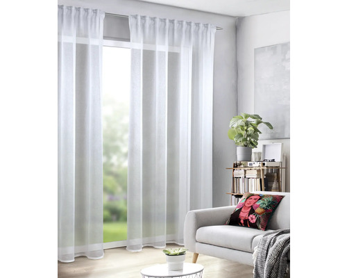 Obývacia izba s bielymi, priehľadnými závesmi pred oknom