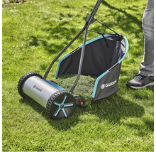 Ručná kosačka na trávu na trávniku so zberným košom