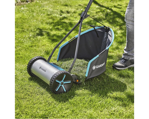 Ručná kosačka na trávu na trávniku so zberným košom