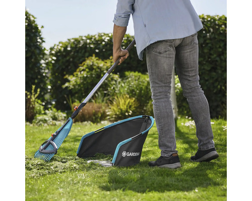 Záhradná scéna so záhradníkom zametajúcim trávnik hrabľami na lístie a zberačom trávy od firmy Gardena