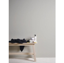 Svetlá a priateľská kúpeľňová scéna s drevenou lavicou, kúpeľňovým textilom a produktmi starostlivosti