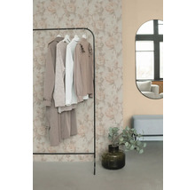 Stojan na oblečenie s oblečením, zrkadlom a dekoráciou v miestnosti.