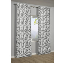 Dekoratívne závesy s grafickým vzorom pred oknom.