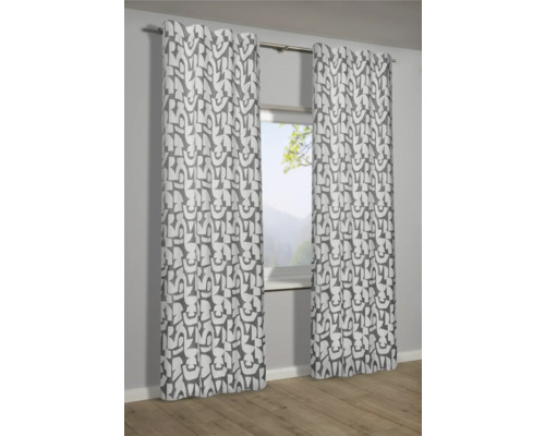 Dekoratívne závesy s grafickým vzorom pred oknom.