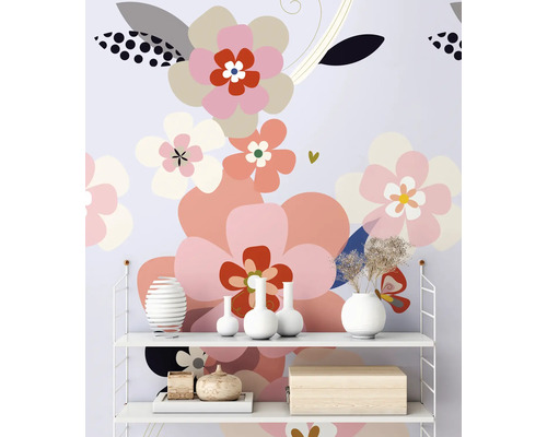 Polica s dekoratívnymi predmetmi pred tapetou so vzorom kvetov